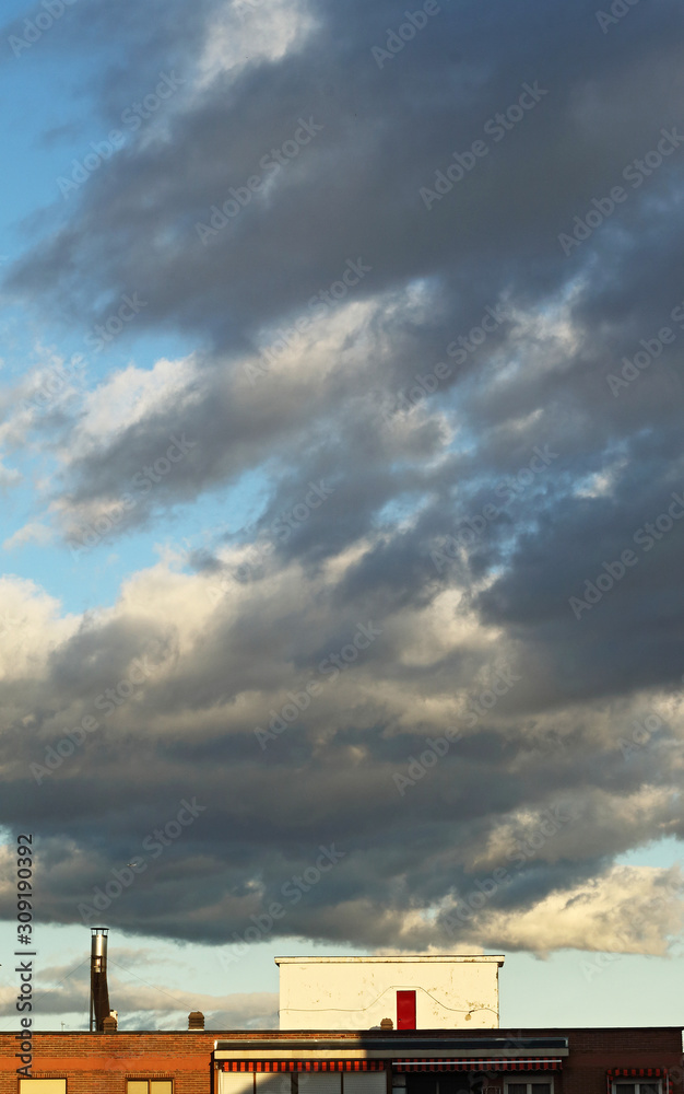 Rooftops and landscape, sky with clouds