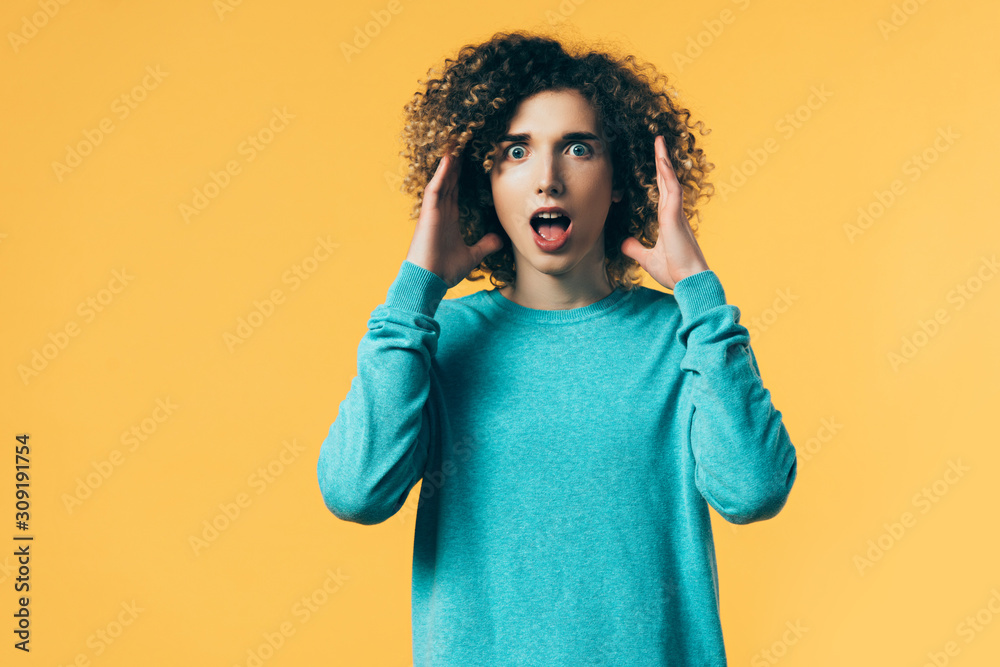 scared curly teenager with open mouth isolated on yellow scared curly teenager with open mouth isolated on yellow