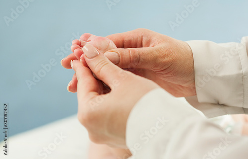 Mother love Mother holding her little baby's feet, close up.Concept skin examination by a doctor