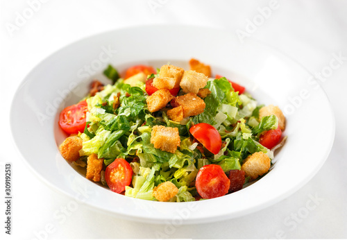 Fresh garden salad with croutons on a white background