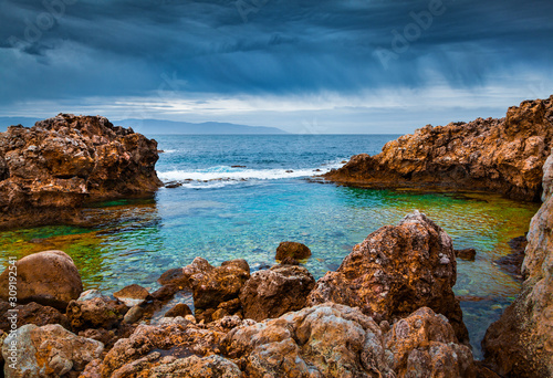 Fototapeta Naklejka Na Ścianę i Meble -  Few minutes before the storm. Dramatic summer view of volcanic beach on nature reserve Piscina di Venere, cape Milazzo, Sicily, Italy, Europe. Amazing evening sescape of Mediterranean sea.