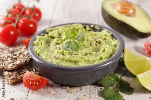 homemade guacamole with bread, tomato and lime