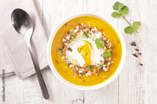 pumpkin soup with cream and nuts in bowl