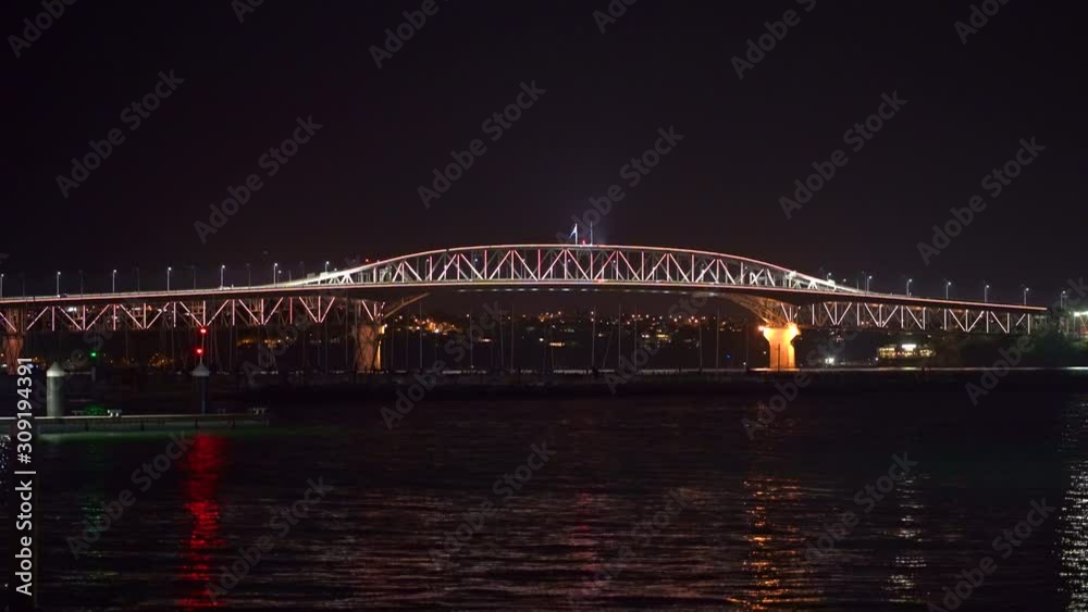 Bridge in Auckland during nigh time dark sky with lights and traffic over the water Bridge in Auckland during nigh time dark sky with lights and traffic over the water