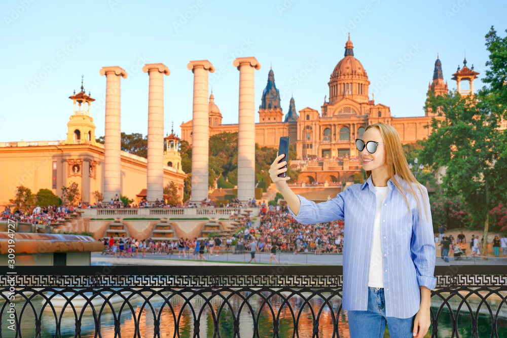 Obraz premium Young Woman Taking selfie against The Catalania National Museum. Young woman with digital gadget in the old historical streets of Barcelona.