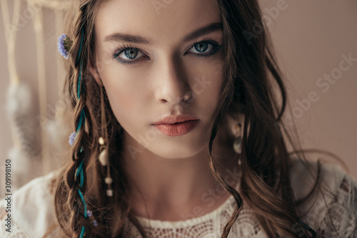 beautiful tender girl with braids in white boho dress on beige
