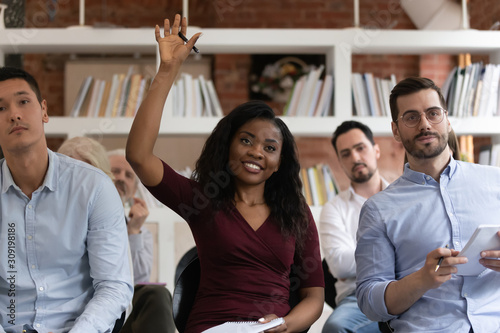 Canvas Print African woman raising hand to ask question at team training