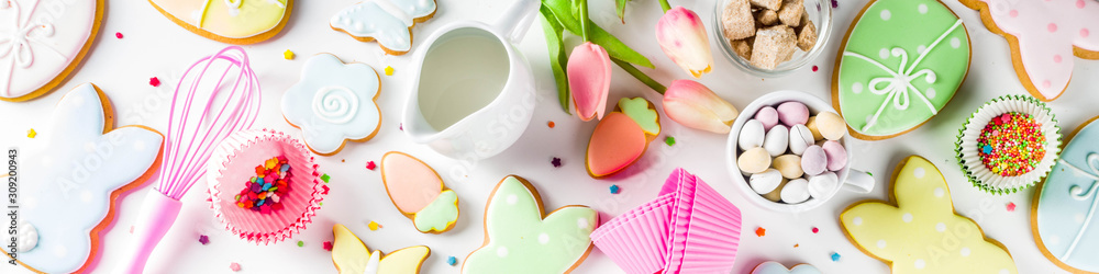 Sweet Easter baking cooking background with traditional Easter bunny and egg cookies, sugar sprinkles, ingredients, utensils. White table background copy space layout Sweet Easter baking cooking background with traditional Easter bunny and egg cookies, sugar sprinkles, ingredients, utensils. White table background copy space layout