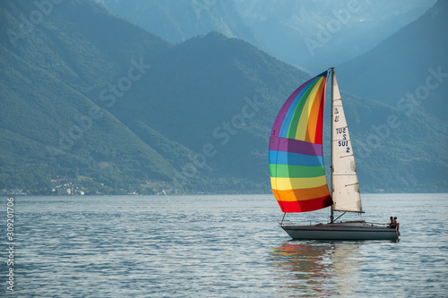 Yacht with rainbow sail in Geneva lake