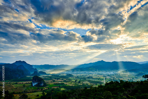 Landscape view of countryside morning while sunrise shining from the sky hitting the mountains and land