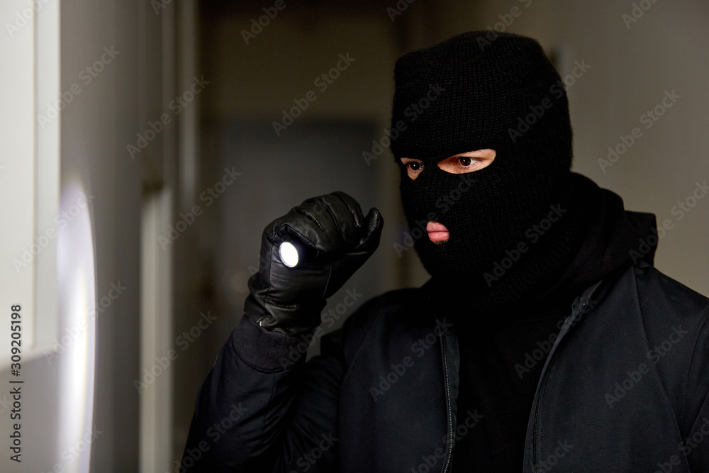 Burglar at night with flashlight and balaclava Burglar at night with flashlight and balaclava