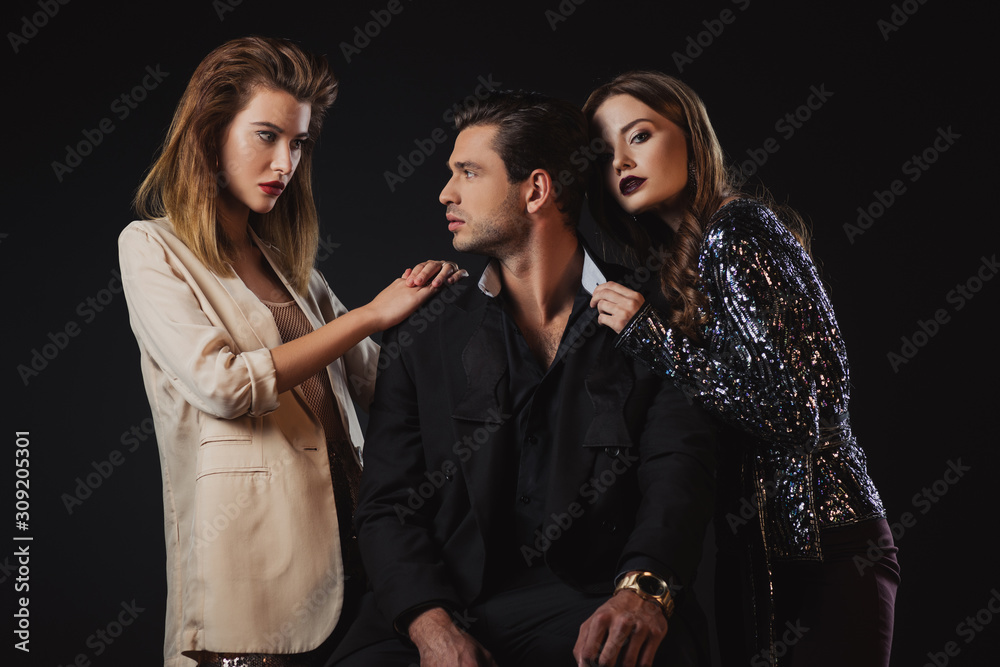 attractive and stylish women hugging handsome man isolated on black attractive and stylish women hugging handsome man isolated on black