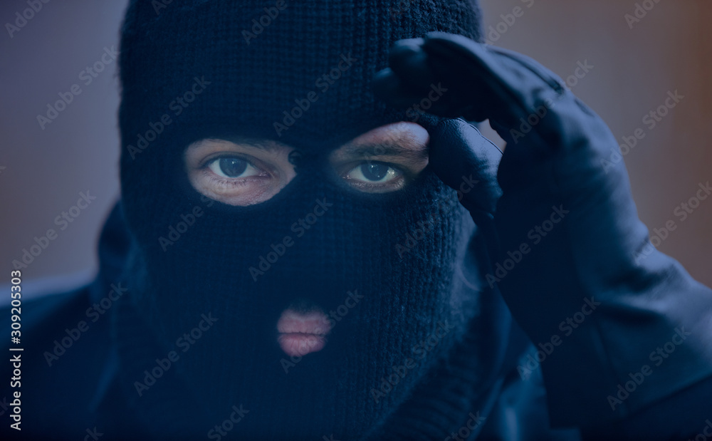 Burglar with storm mask while spying