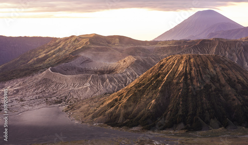 View from above, stunning aerial view of the Mount Batok, Mount Bromo and the Mount Semeru in the distance illuminated at sunrise, East Java, Indonesia.