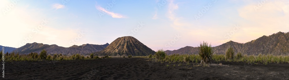 Stunning panoramic view of the Mount Batok and the Mount Bromo illuminated during a beautiful sunrise. Mount Bromo is an active volcano in East Java, Indonesia.
