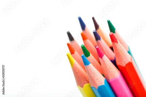 Colored pencils close up on white background, free space for text.