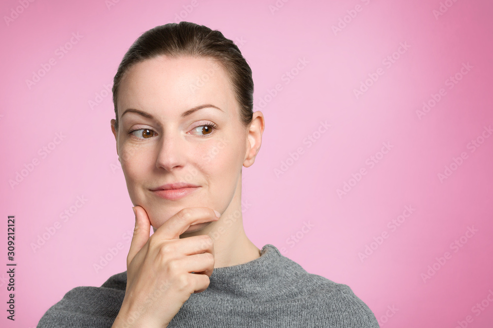 young pretty woman with hand at her chin is thinking young pretty woman with hand at her chin is thinking