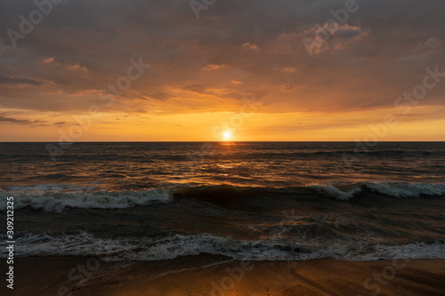 Fototapeta Naklejka Na Ścianę i Meble -  Panoramic view of sunset in ocean. Nothing but sky, clouds, beach and water. Beautiful serene scene