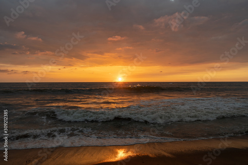 Fototapeta Naklejka Na Ścianę i Meble -  Panoramic view of sunset in ocean. Nothing but sky, clouds, beach and water. Beautiful serene scene