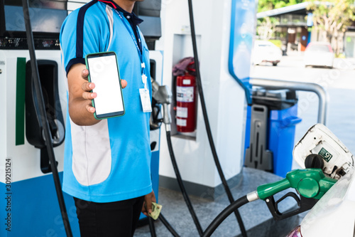 Man gas station staff is holding smartphone to provide for online payment or transaction.
