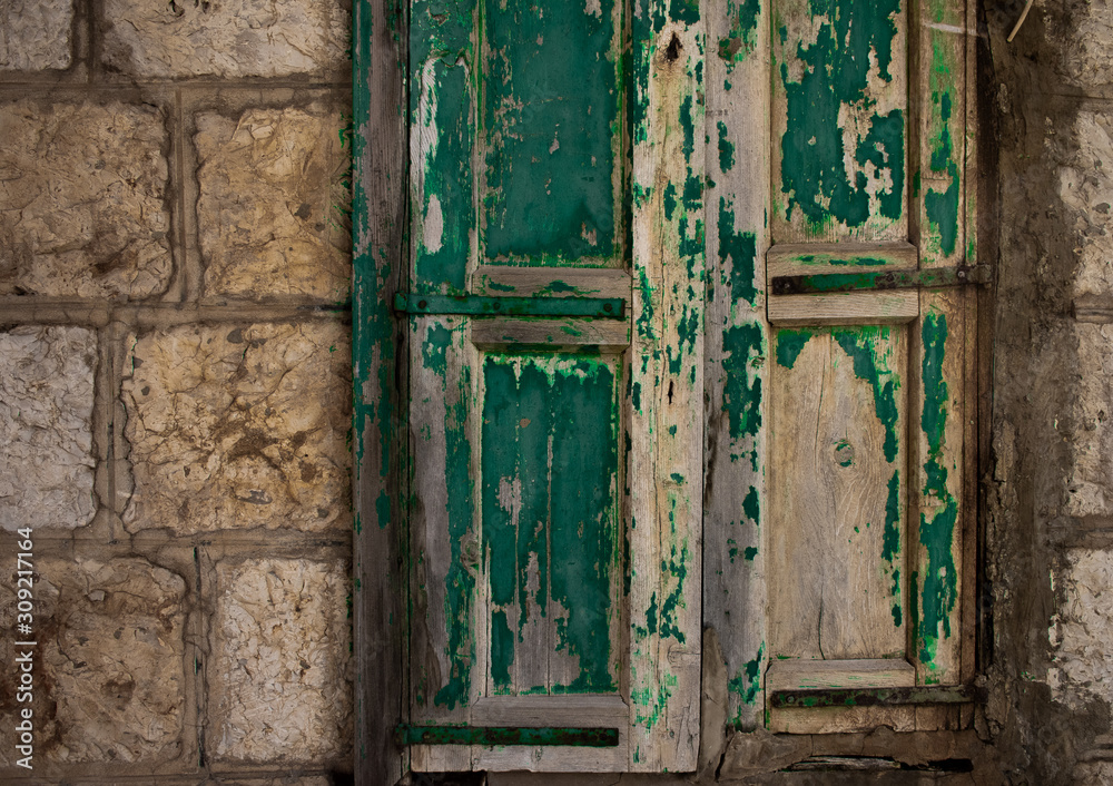 old green weathered door on a stone building