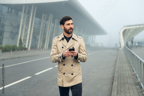 Businessman texting messages while walking.