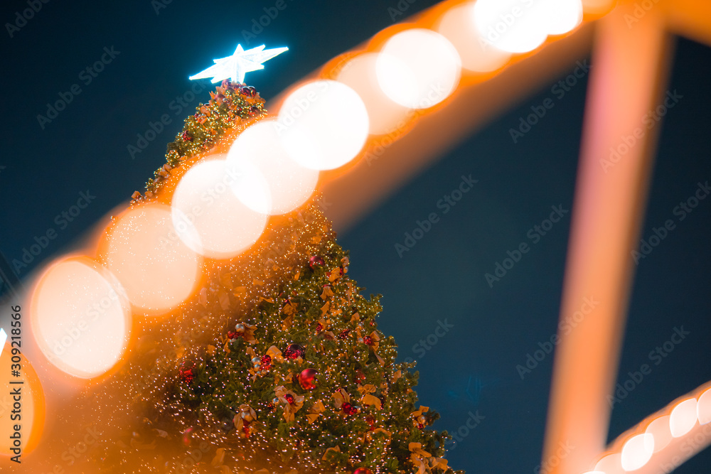 Christmas and new year holiday event with shiny and glitter ornament ball with lot of small light decorate on big Christmas tree with soft focus bokeh background