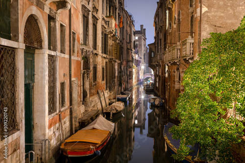 boats docked on a beautiful canal in venice © Florincristian