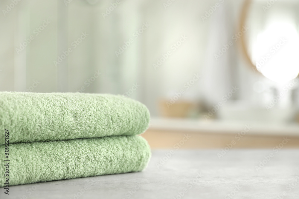 Stack of clean towels on table in bathroom. Space for text Stack of clean towels on table in bathroom. Space for text