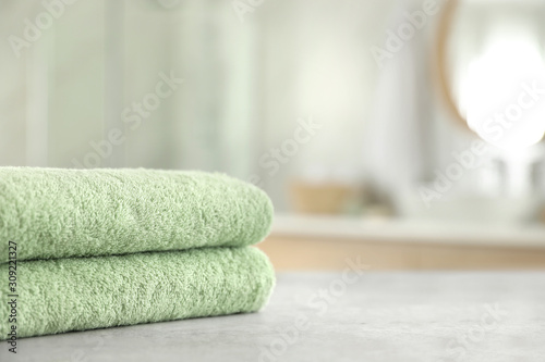 Stack of clean towels on table in bathroom. Space for text