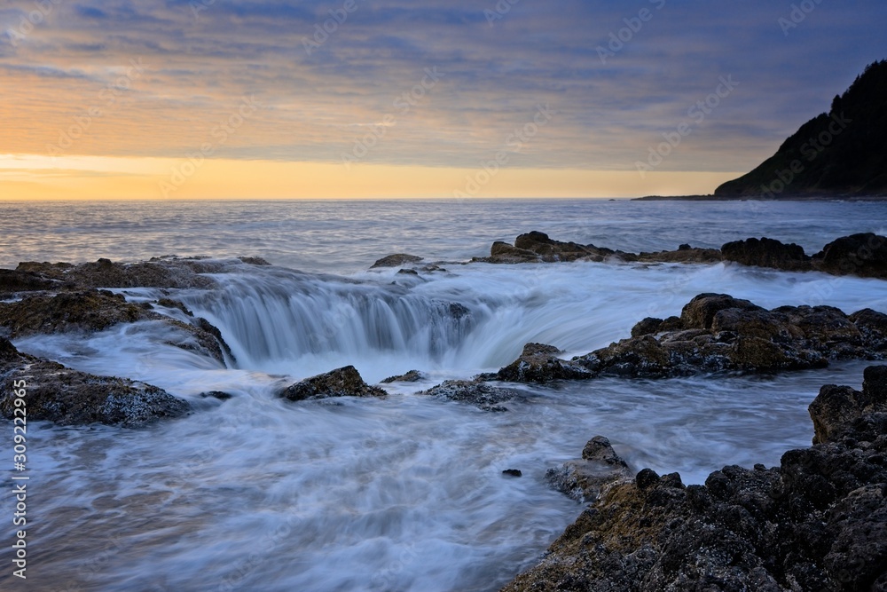 Water rushing into Thor's Well during dramatic sunset Cape Perpetua Oregon Coast