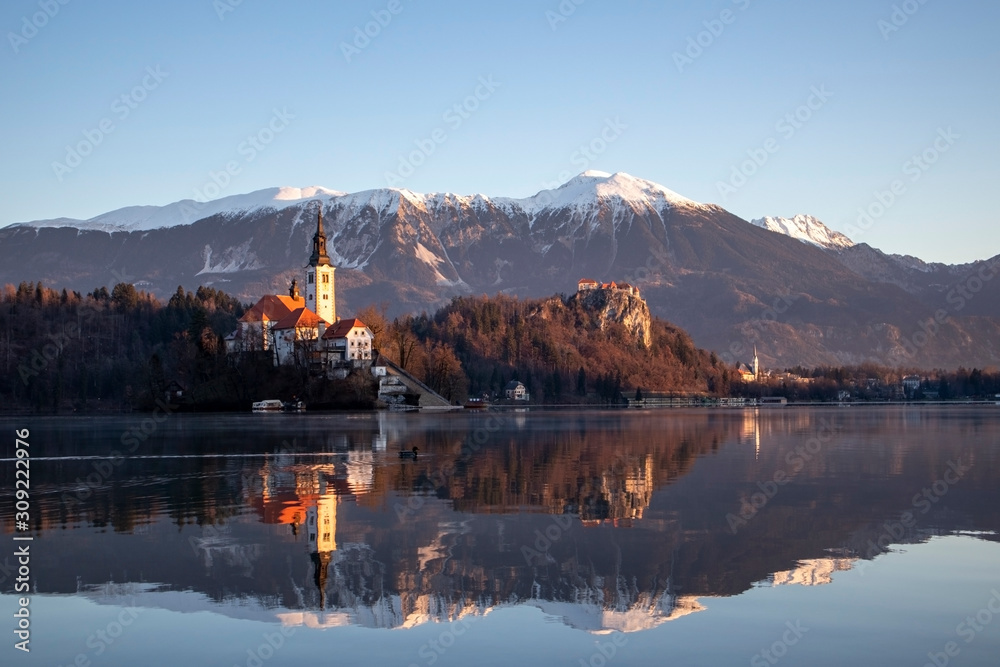 Sunrise view of lake Bled in sunny winter with the island, castle and church Sunrise view of lake Bled in sunny winter with the island, castle and church