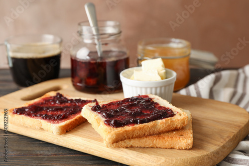 Composition with delicious toasts with jam on wood board, close up