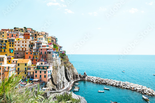 A beautiful landscape of the Manarola village of Cinque Terre located in northern Italy and the blue sea with yachts and boats