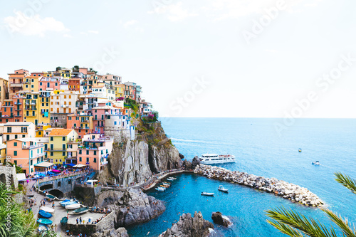 A beautiful landscape of the Manarola village of Cinque Terre located in northern Italy and the blue sea with yachts and boats