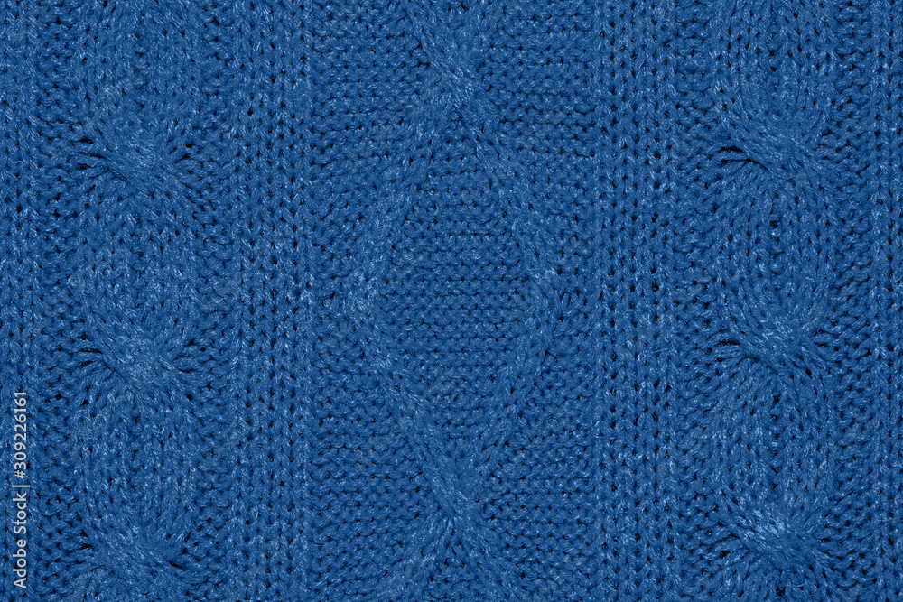 Large woolen background knitted from blue thread. View from above. Element of clothes, style drawing.