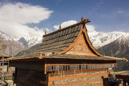 The beautiful gabled rooftop of an ancient Hindu temple made of wood and stone in the traditional Kinnauri style in the village of Kalpa in the Indian himalayas.