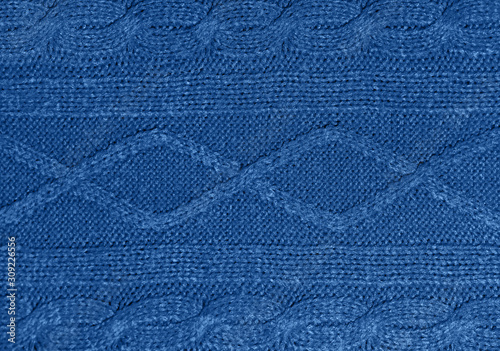Large woolen background knitted from blue thread. View from above. Element of clothes, style drawing.