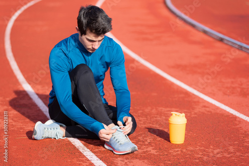 Obraz na plátně Close up view, of an athlete tying his shoe laces