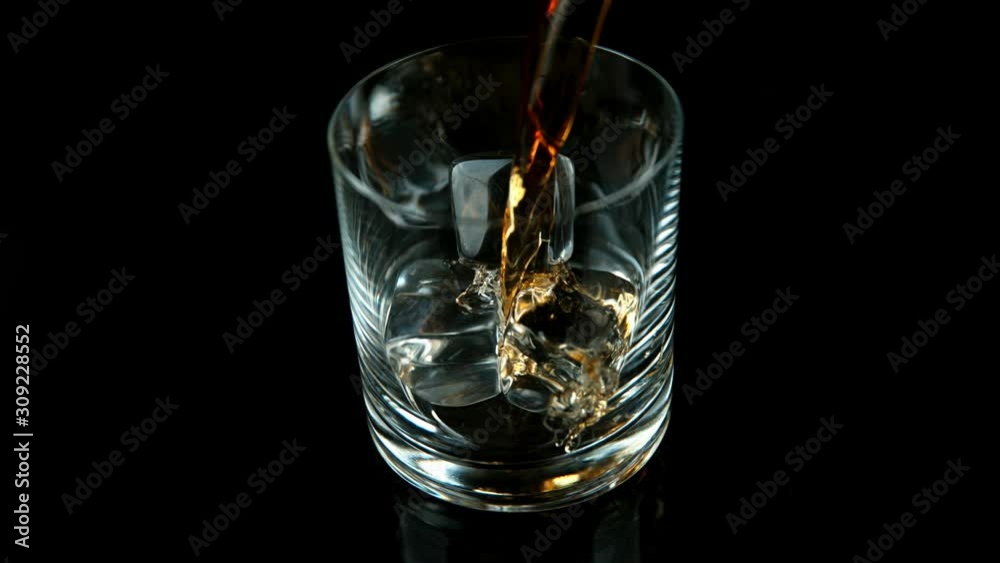 Super slow motion of pouring whiskey into glass. Filmed on high speed cinema camera, 1000fps