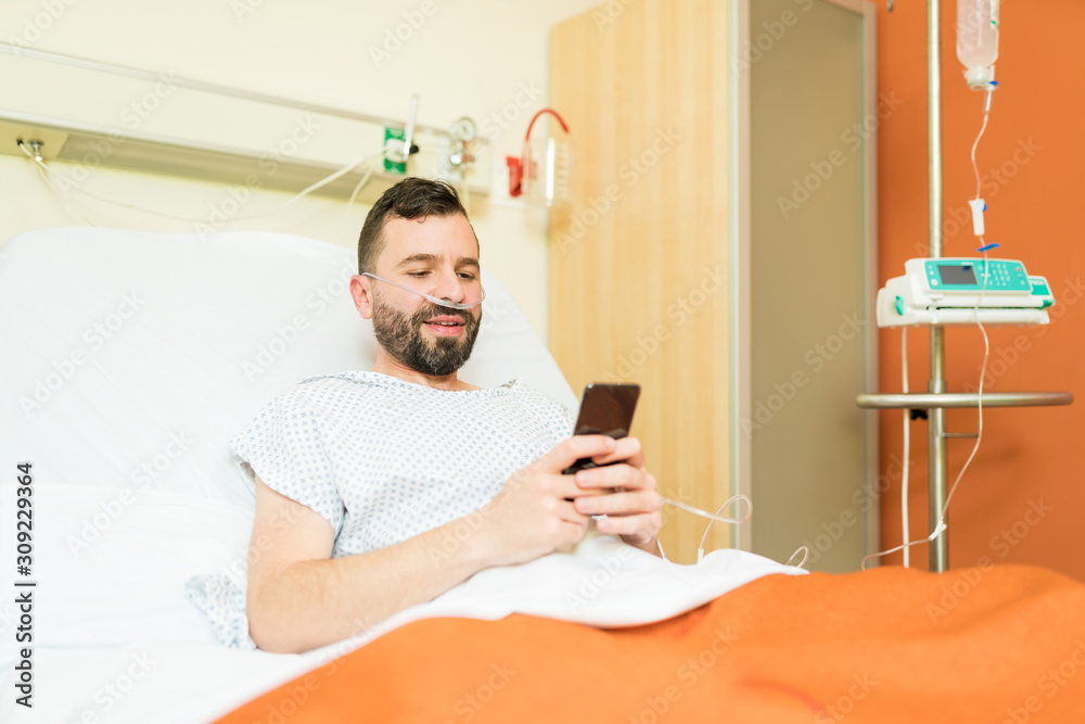 Male Patient Texting On Cellphone In Hospital Male Patient Texting On Cellphone In Hospital