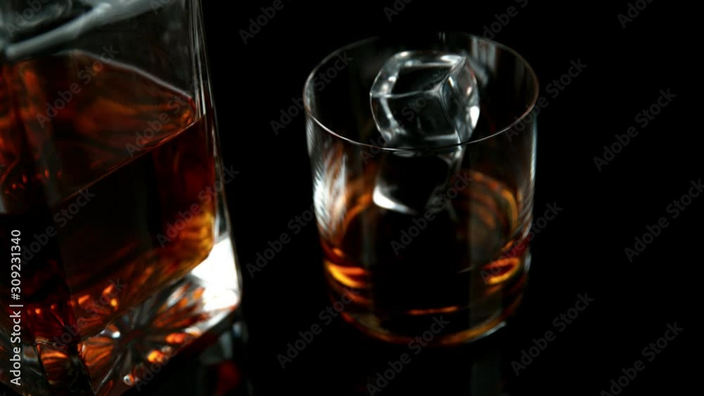 Super slow motion of falling ice cube into whiskey drink. Filmed on high speed cinema camera, 1000 fps. Super slow motion of falling ice cube into whiskey drink. Filmed on high speed cinema camera, 1000 fps.