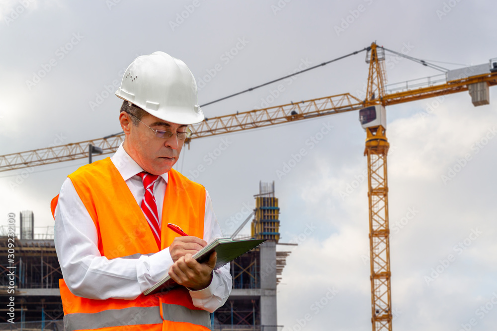 Construction engineer man in shirt and tie with safety helmet and vest works at construction site. Concept of people working in industrial field Construction engineer man in shirt and tie with safety helmet and vest works at construction site. Concept of people working in industrial field