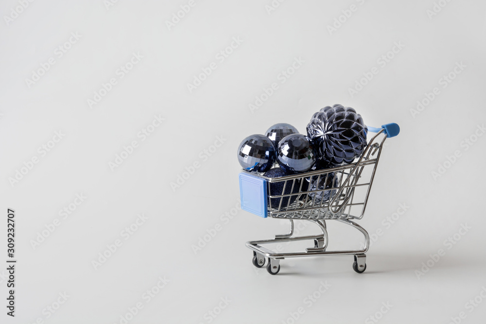 Grocery cart full of New Years classic blue balls. Minimal Christmas holiday shopping concept. Space for text.