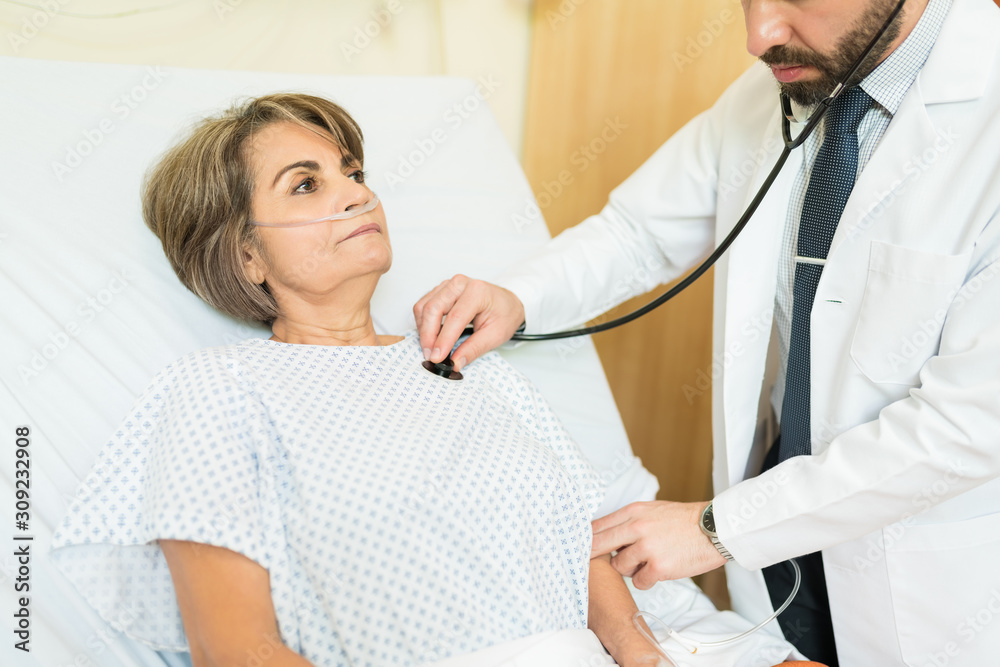 Obraz premium Doctor Examining Elderly Patient In Hospital