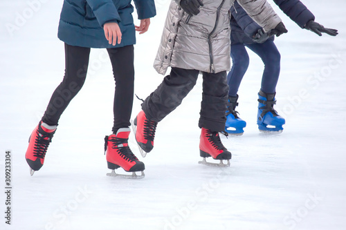 different people are actively skating on an ice rink. Hobbies and sports. Vacations and winter activities.