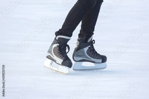 legs of a skating man on an ice rink.