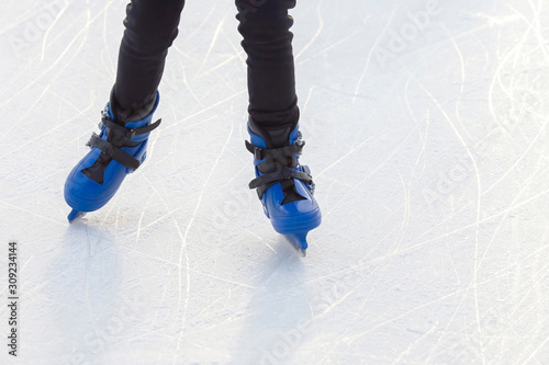 legs of a skating man on an ice rink. Hobbies and sports. Vacations and winter activities.