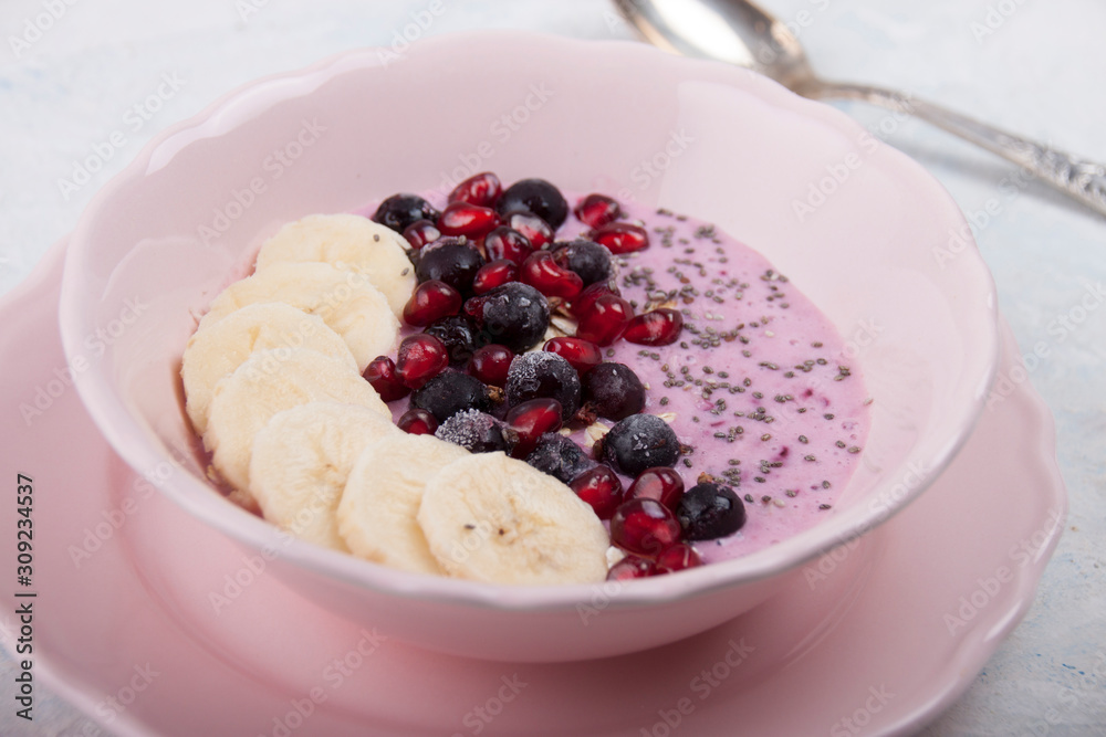 Smoothie bowl with banana, blackcurrant, pomegranate seeds, oatmeal and chia seeds Smoothie bowl with banana, blackcurrant, pomegranate seeds, oatmeal and chia seeds