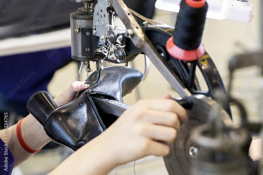 Obraz premium Cropped image of young shoemaker in workshop making shoes.